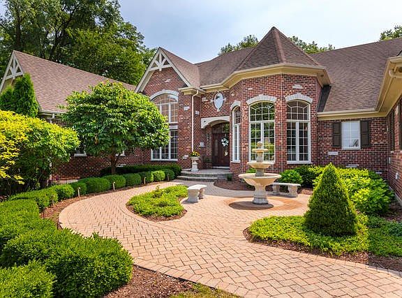 The brick paver walkway in front leads to a piazza and a three tiered fountain outside the front ent