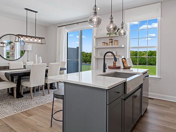 Island kitchen open to casual dining area in a DRB Homes Whitaker II model at the Rolling Hills com