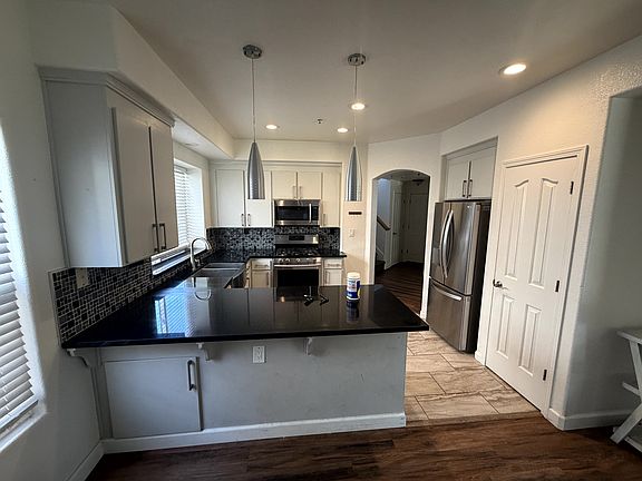 Updated kitchen featuring granite countertops, stainless steel appliances, and a breakfast bar.