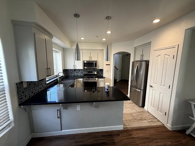 Updated kitchen featuring granite countertops, stainless steel appliances, and a breakfast bar.