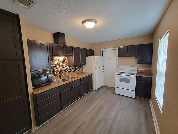 Kitchen With Fridge, Stove and Microwave