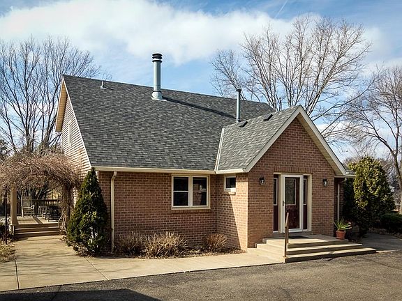 Wide concrete stairs and sidewalks abut the driveway for easy entry to the home.  The brick face and entry door with dual sidelights make an attractive front to this house.