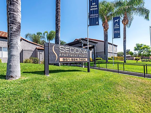 Sedona Apartments in Moreno Valley welcomes you with a modern, inviting entrance framed by lush landscaping and stylish, well-lit pathways.