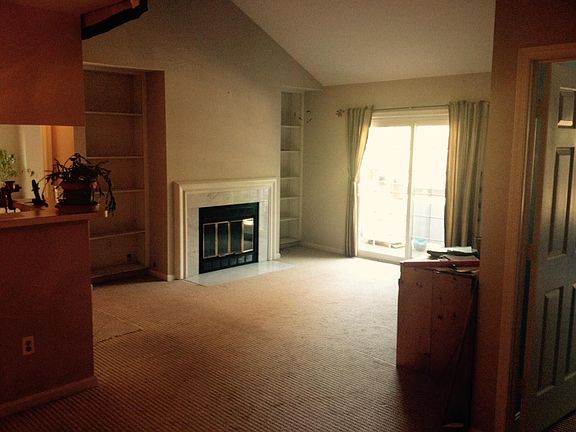 Large living room, cathedral ceilings, fireplace, built in bookcases and balcony.