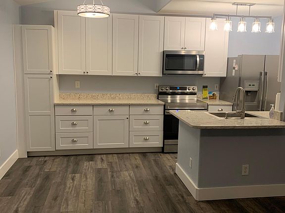 Open kitchen with lots of cabinets and pantry. Stainless appliances, quartz countertops.