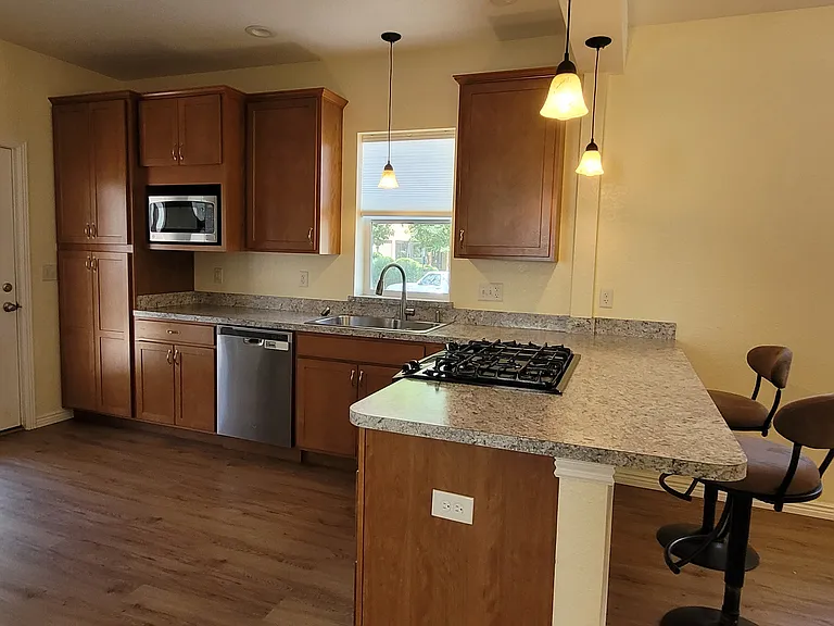 Spacious kitchen with lots of cabinet space, in case you like to cook! Kitchen island separates kitchen and living room in open space plan.