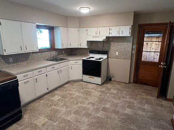 Kitchen includes an electric stove and moveable dishwasher.