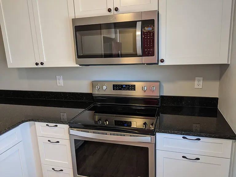 Stainless Microwave, range, and oven with ample preparation space.