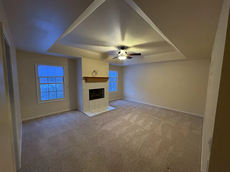 Primary Bedroom with gas fireplace and tray ceiling
