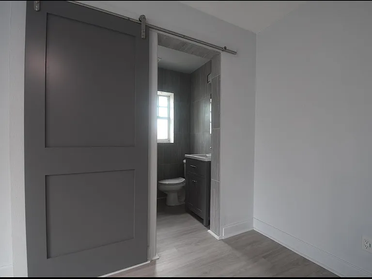 Barn-door entry into the bathroom from the bedroom.