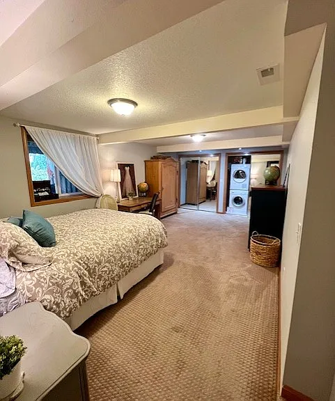 View from bedroom door looking in to the spacious master. Includes desk, large armoire, and dresser with plenty of closet space! Carpeted floor provides warmth and comfy feeling.