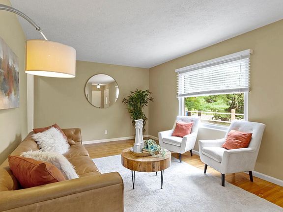 Staged living room with south facing picture window, hardwood floors, fresh paint.