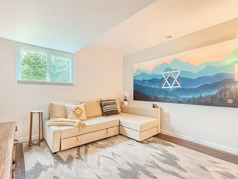 A cozy bedroom with a modern sectional that easily transforms into a sofa bed_perfect for relaxing with a book or accommodating extra guests.