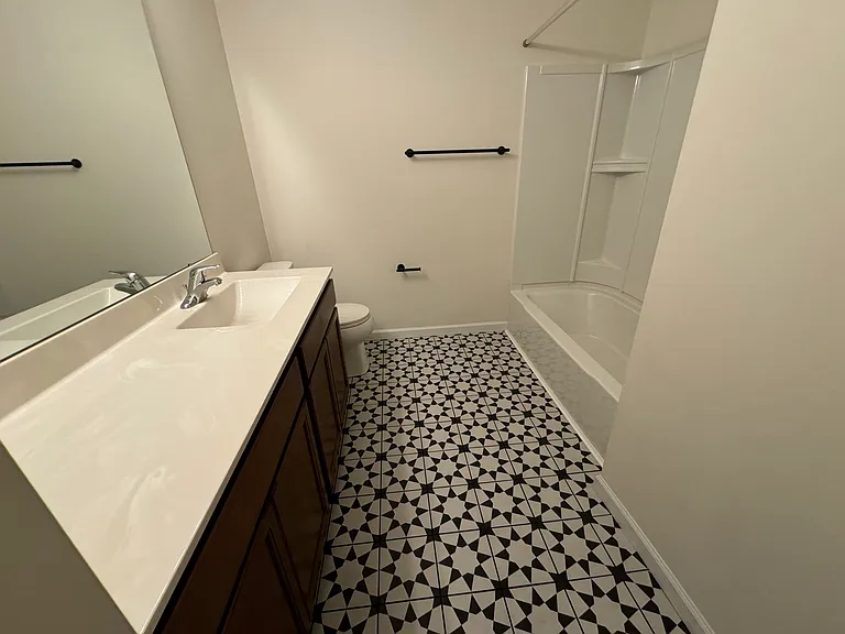 Hall bath with tub and shower, lots of counter space and decorative tile
