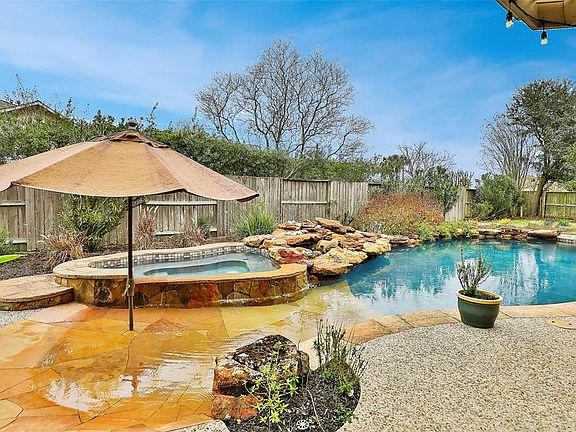 Beach entry pool with heated spa. Trickling rock waterfall. with irrigated planting areas.