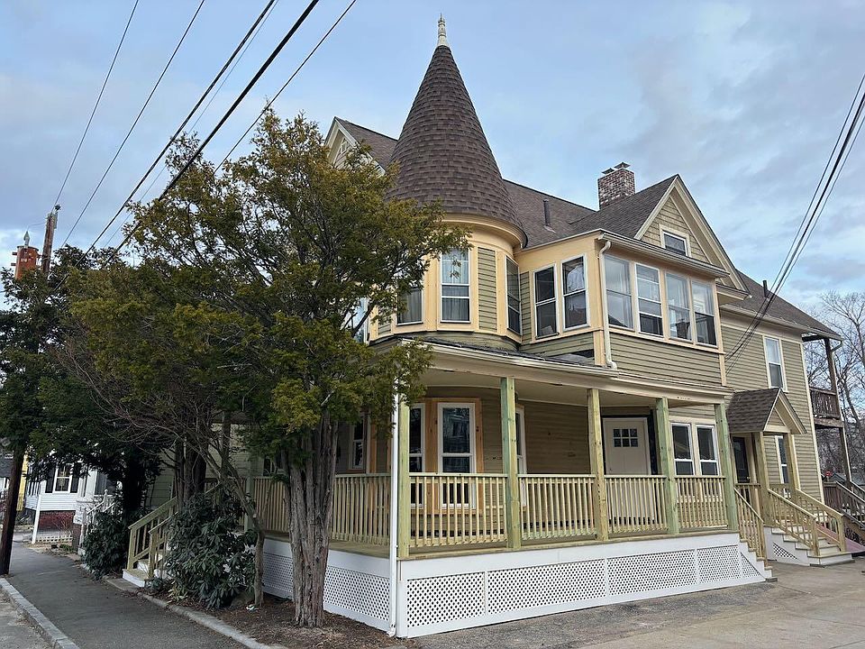 Side of building with off-street parking. Showing side door into unit's living room