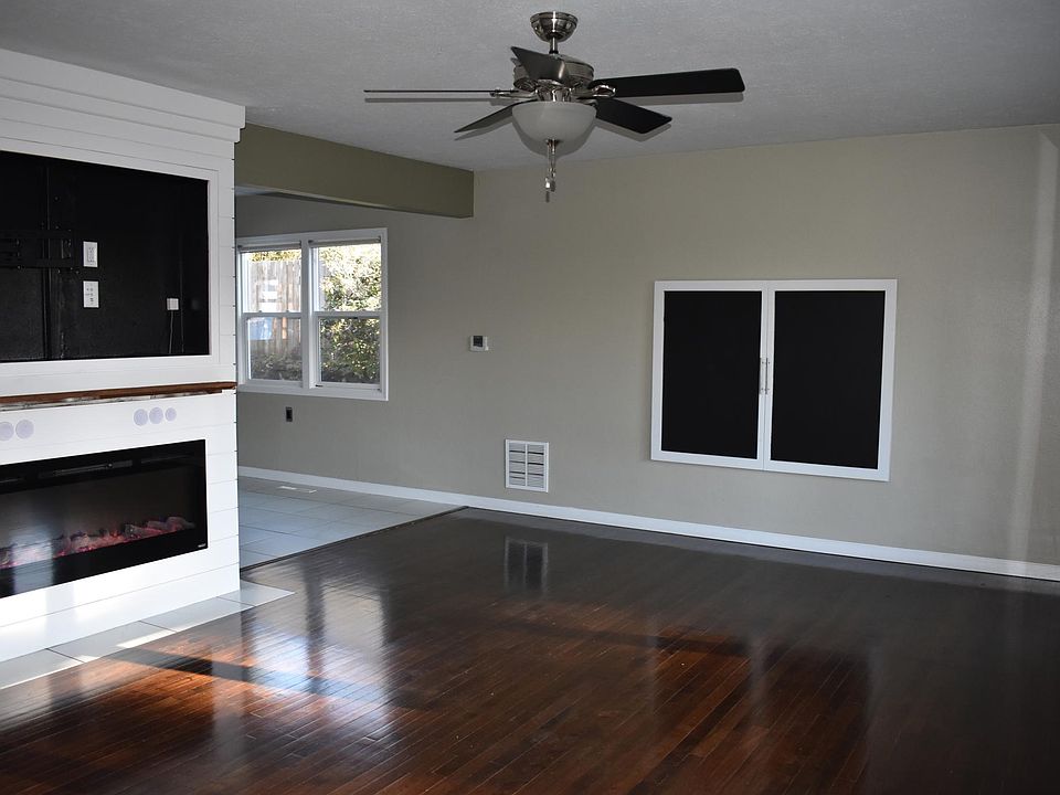 Bright and sunny living room that opens to kitchen with electric fireplace and built in for television