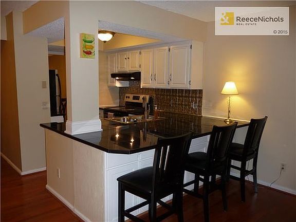 Updated kitchen boasts stainless appliances, granite tile counters, island and extra seating.