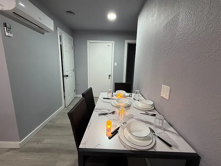 Compact dining nook with a table for four, durable flooring, and overhead lightingideal for everyday meals and takeout night