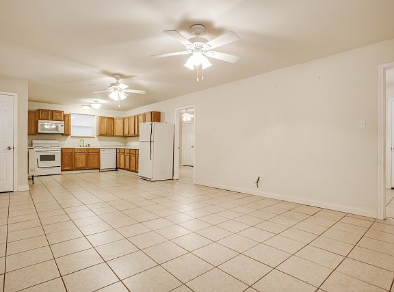Kitchen/Living room area with ceiling fans and entrance to both bedrooms