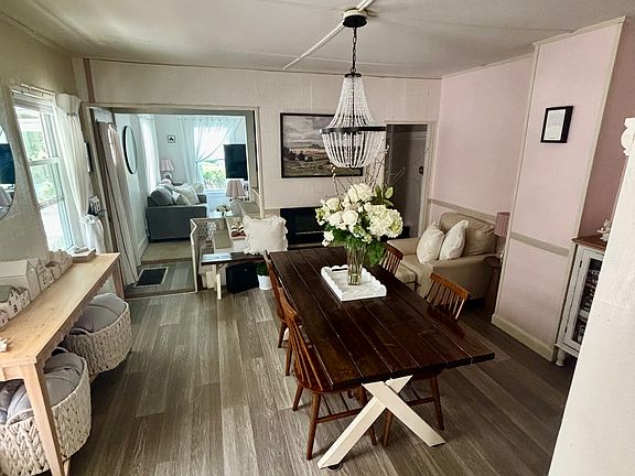 Warm and inviting Dining Room with brand-new flooring, modern light fixtures,and freshly painted walls in Polar White to provide a cozy neutral color pallete.