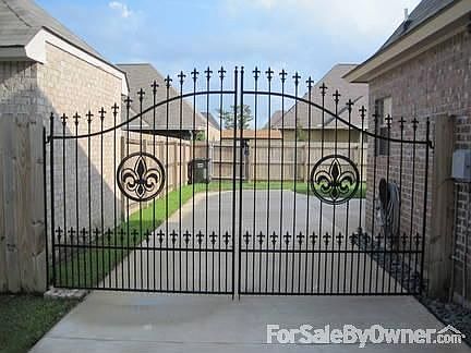 Custom wrought iron fence that has puppy bars and a big fleur-de-lis