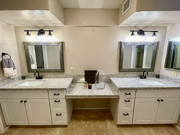 ensuite primary bathroom double vanity with granite countertops