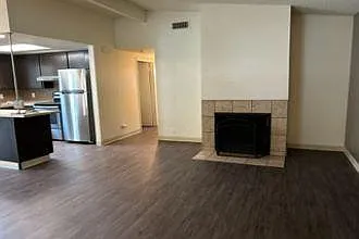 Living room with wood-burning fireplace, fresh paint, accent wall, and vinyl plank flooring