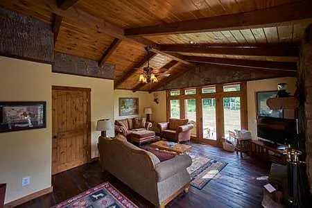 Lovely living room, cathedral ceiling, wood burning fireplace, hand-hewn floors.