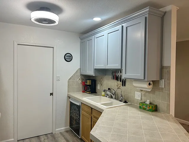 Kitchen with many knives and coffee makers.
