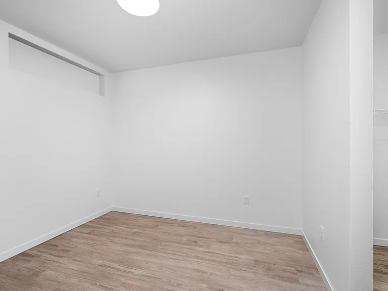 Bright, open bedroom with sleek wood flooring and a spacious closet, perfect for modern living. Bright, open bedroom with sleek wood flooring and a spacious closet, perfect for modern living.