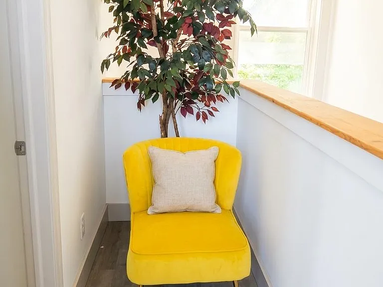 Quiet upstairs nook with a large window, durable flooring, and a built-in ledgeideal for reading or a small work setup.
