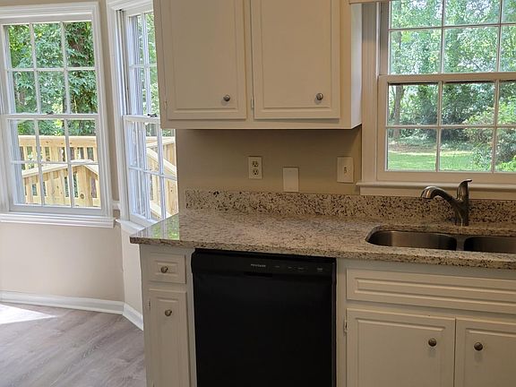 Another view of kitchen with door to deck and large private fenced in back yard