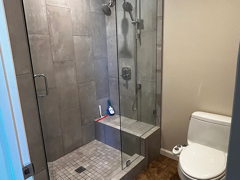 Private bathroom, shower and toilet behind closed door, sink in entry of room