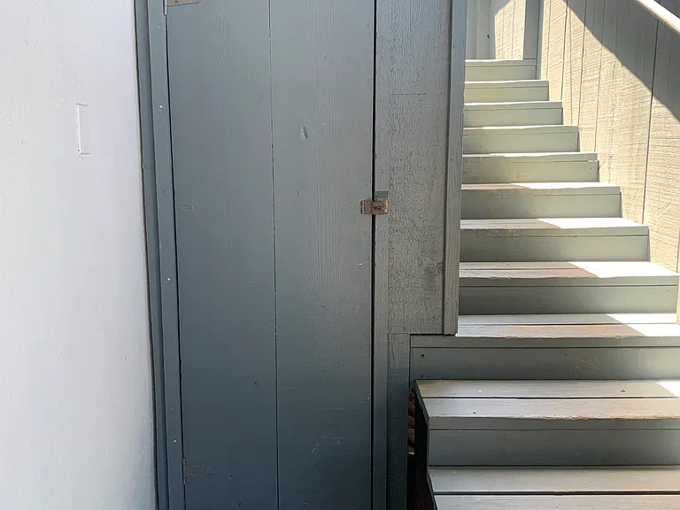 Outdoor storage closet under stairwell