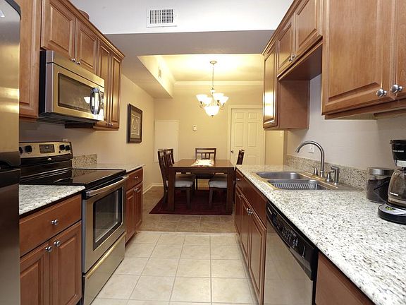 The updated Kitchen (13x8) features stunning granite countertops, stained maple cabinetry, stainless steel appliances, neutral tile floors, and more.