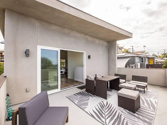 Looking back onto the large deck shows the outdoor furniture and the large stackable door that opens up into the kitchen.