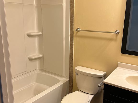Bathroom with tile floor and area above the surround.