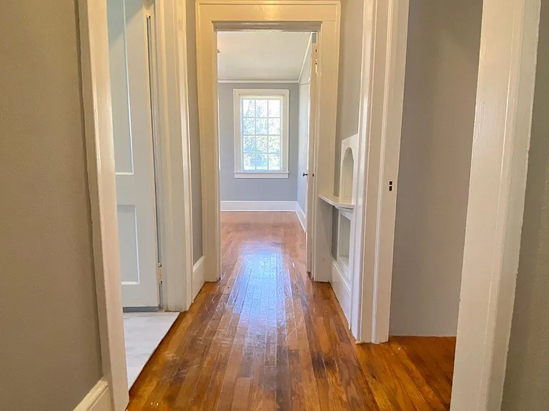 Hallway connecting 2 bedrooms and bathroom. Dining room to the right. Bathroom to the left.