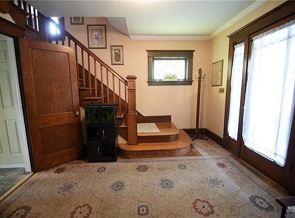 The spacious entry foyer features stained glass windows and hardwood flooring.