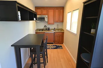 Kitchen fully stocked. Dining table also acts as a desk with plenty of storage above.