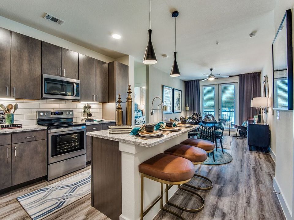 Kitchen with espresso cabinetry, speckled granite countertops, white subway tile backsplash, stainless steel appliances, and hard surface flooring