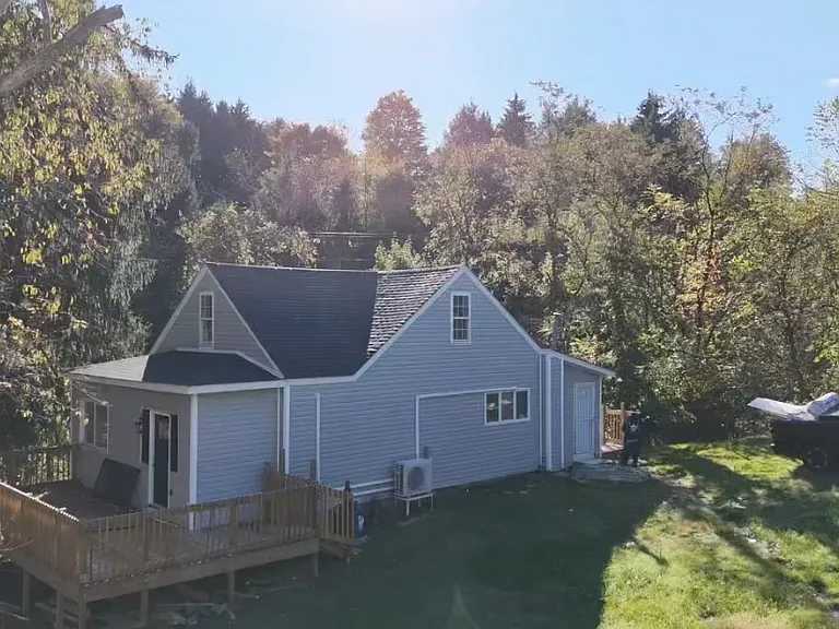 Front view of entrance of home and side view of front porch