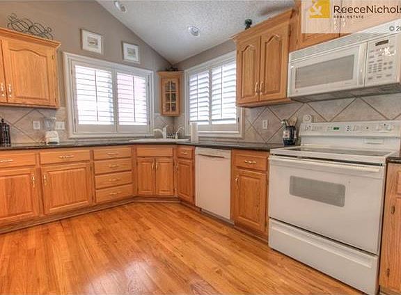 Tall vaulted ceiling and wood floors are featured in the kitchen