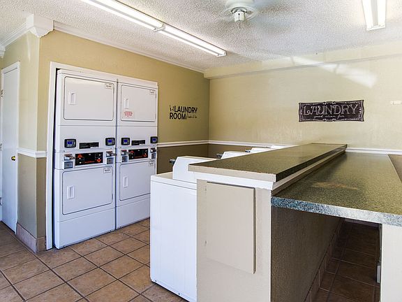 A shared laundry room with multiple washers and dryers