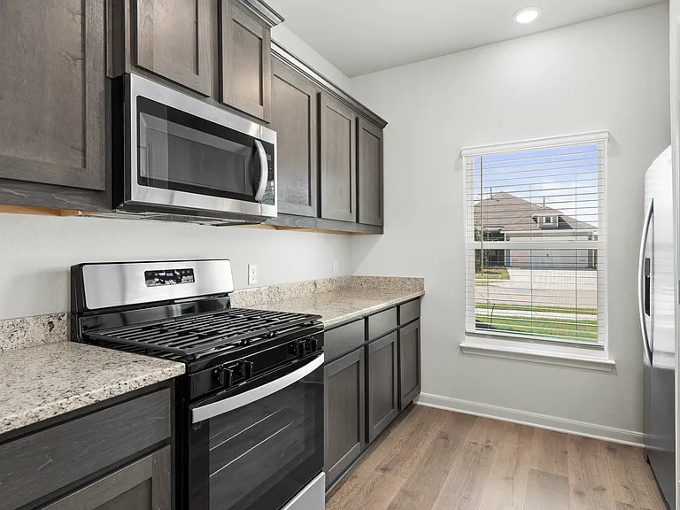 The kitchen has designer wood cabinetry.