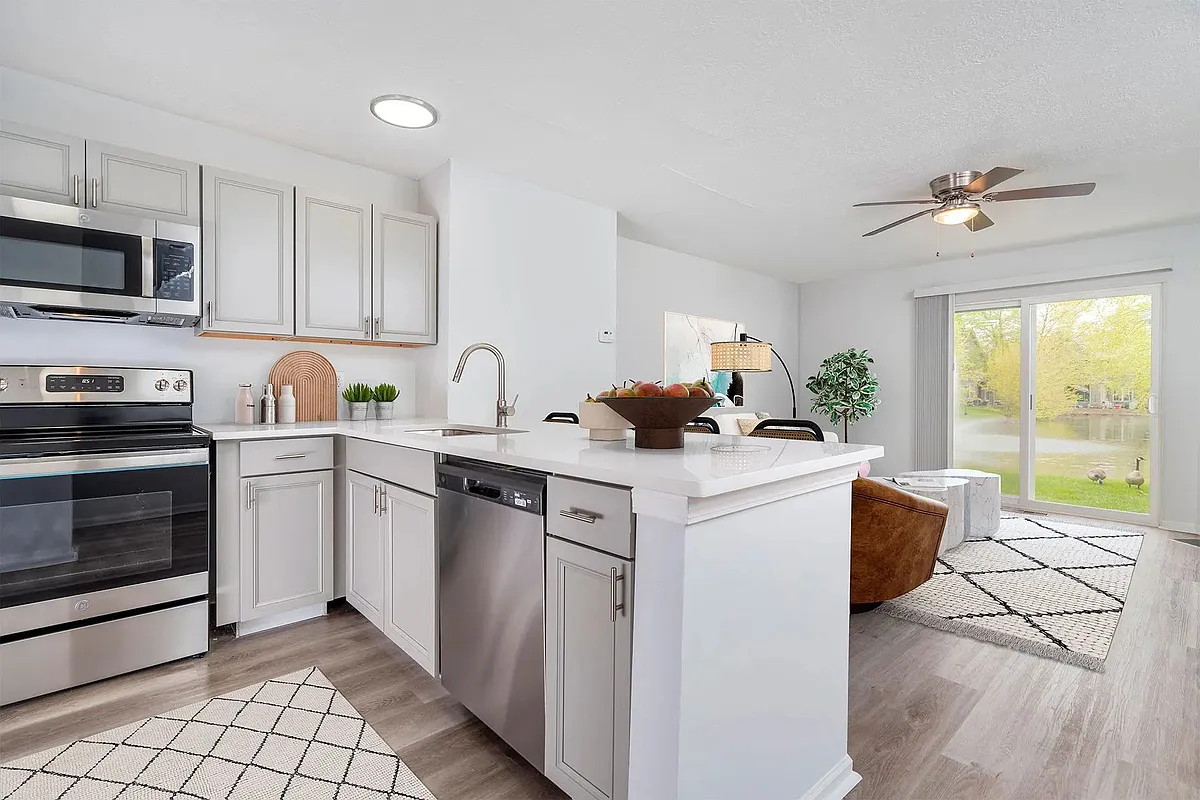 Premium Trentwood kitchen with grey cabinetry, granite countertops, and stainless-steel appliances. - Camden Place