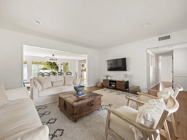 Comfortable living room with generous seating and natural light that opens up to the dining area.