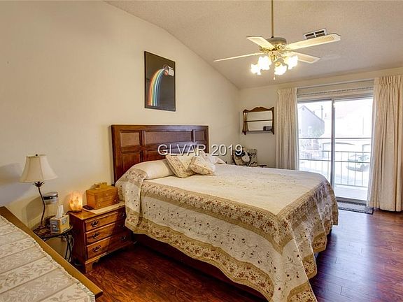 LARGE Master Bedroom with balcony, ceiling fan, laminate flooring and vaulted ceiling.