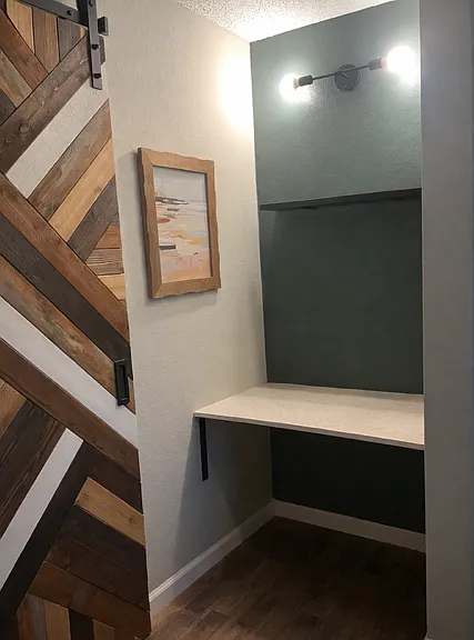 small desk area or vanity area in principle room (barn door leads to the bathroom that is inside the primary room)